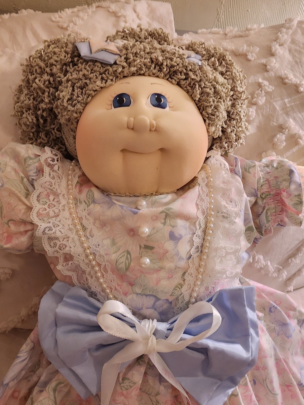Plush Floral Dress Doll with Blue Bow and Pearl Accents